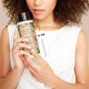 Een model die een fles Love Beauty and Planet shampoo vasthoud